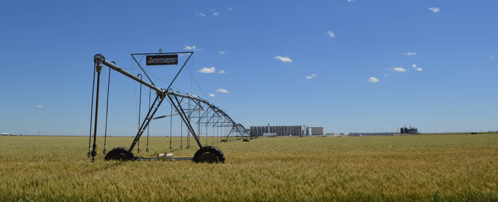 Photo of an irrigation pivot in western Kansas with the coop elevator in the background