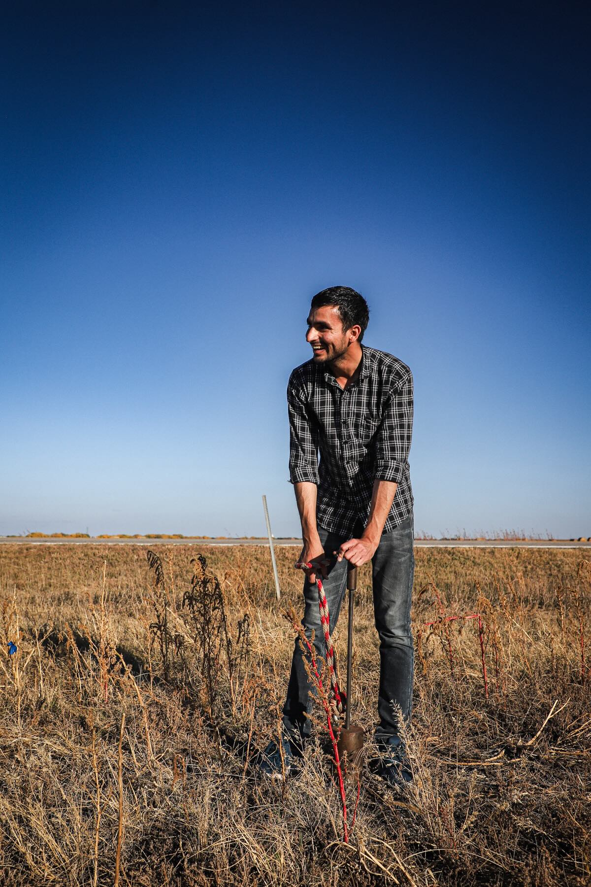 Sachin takes a soil sample at the test plot